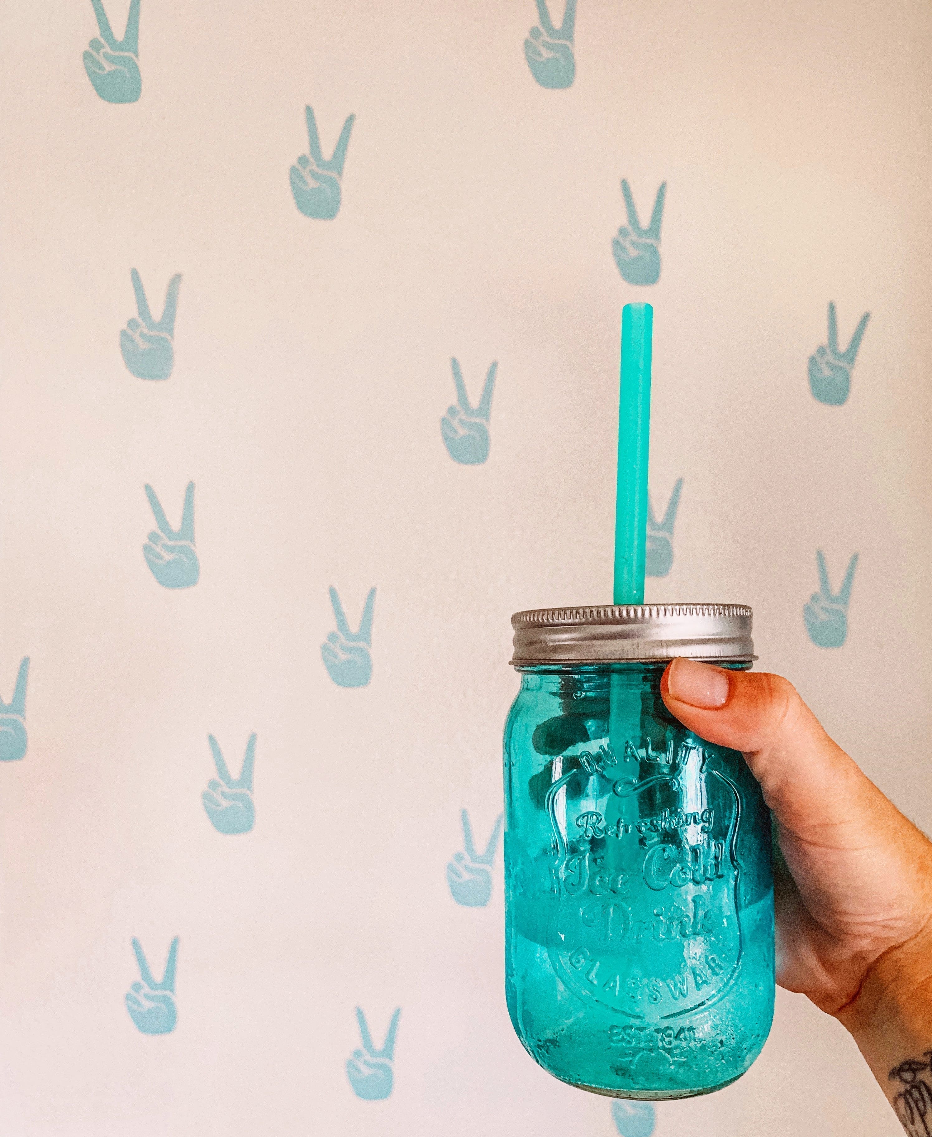 Person sipping a cold drink with a colorful GoSili silicone straw.