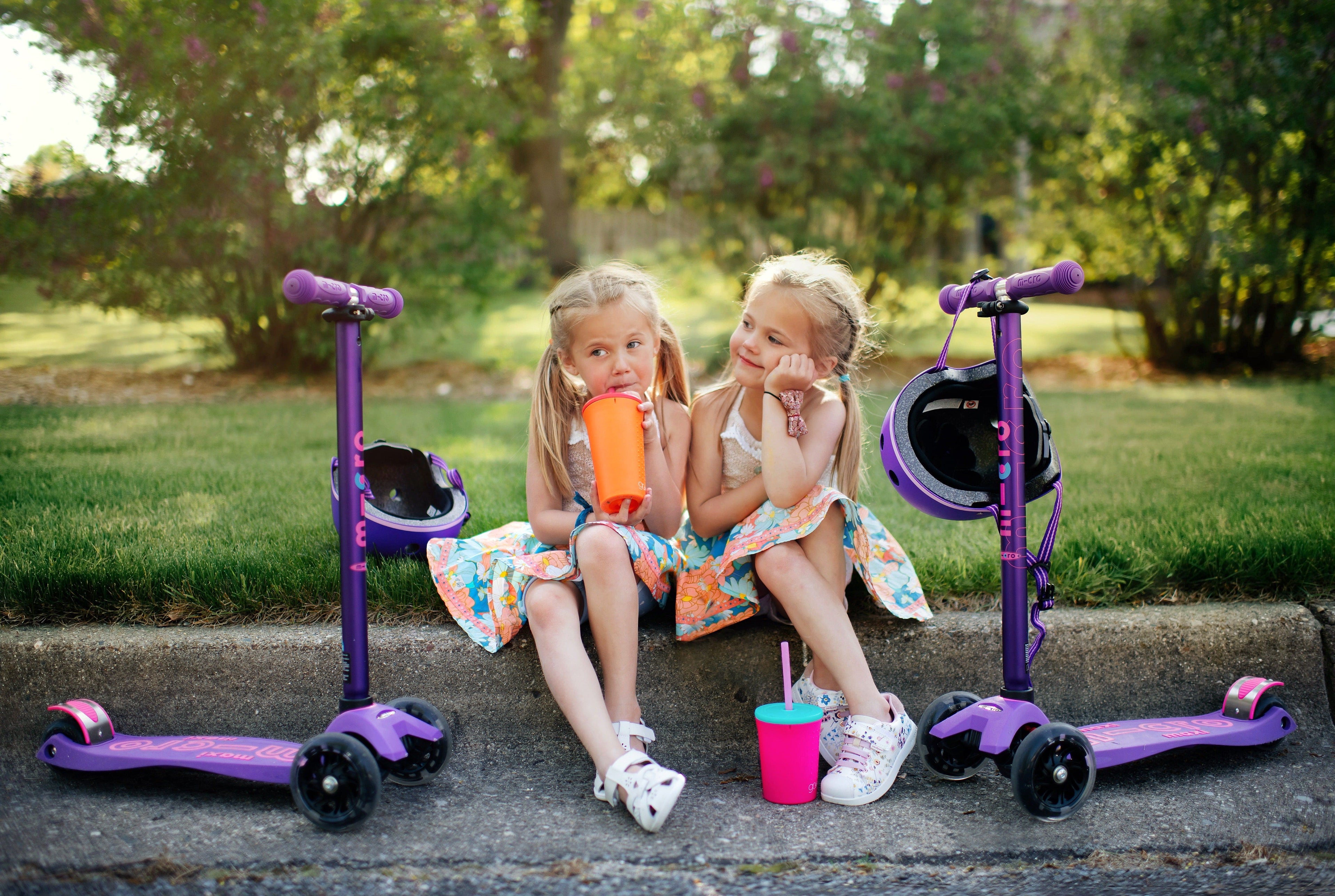 Twin Girls with scooters and silicone reusable straw cups