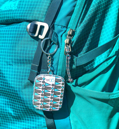 GoSili keychain case hooked to a backpack, carrying a reusable silicone straw.