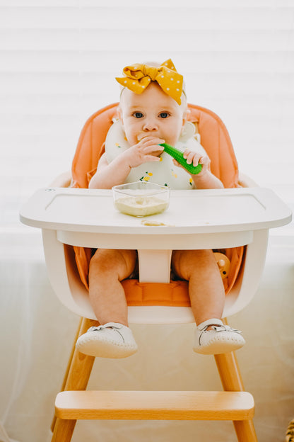 Parent sterilizing a GoSili baby spoon by boiling it in a pot of water.
