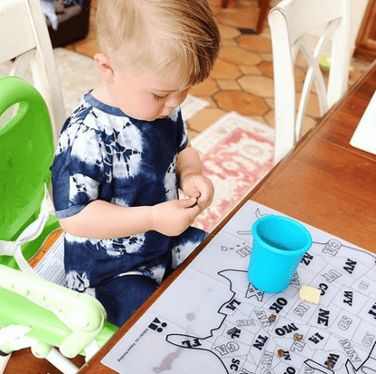 Reusable silicone placemat on a restaurant table, folded for easy portability.
