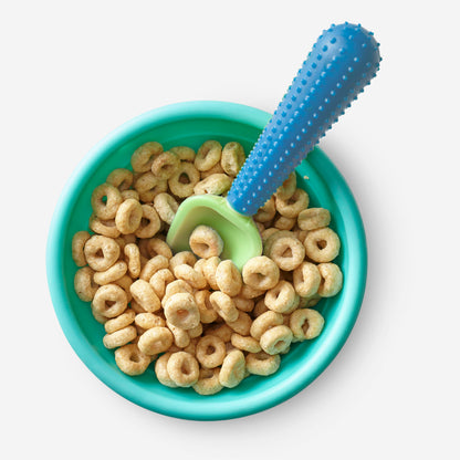 Baby using a GoSili silicone spoon to self-feed during mealtime.
