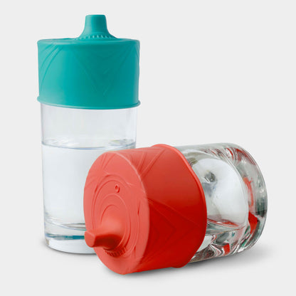 Suction-secured silicone sippy lid on a reusable glass tumbler, spill-resistant.