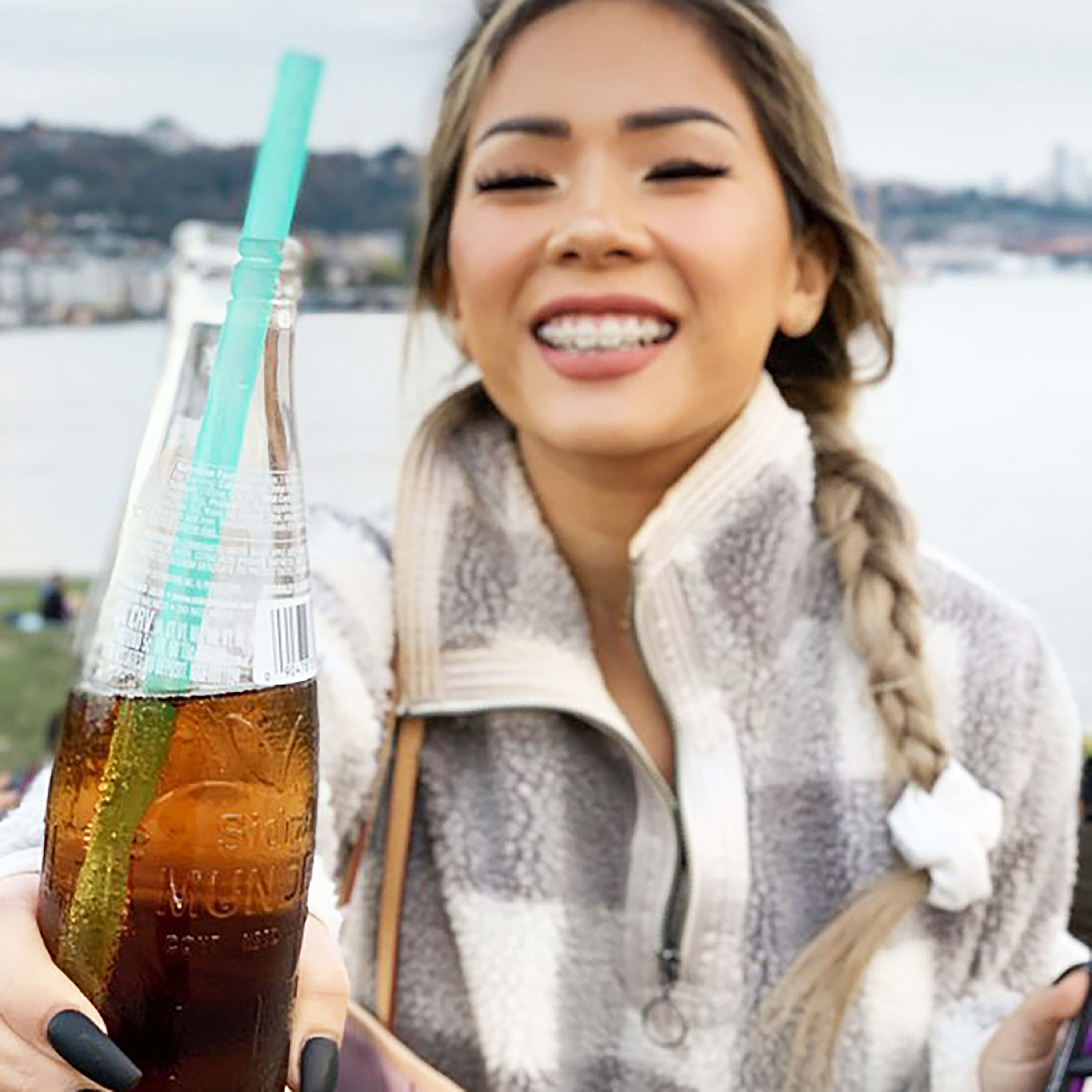 Sustainable silicone straw used for sipping a smoothie at the beach.